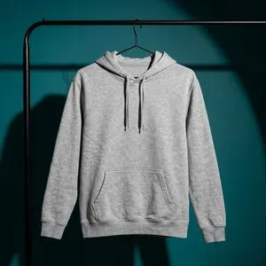 A grey hoodie on a black rail against a deep teal wall.